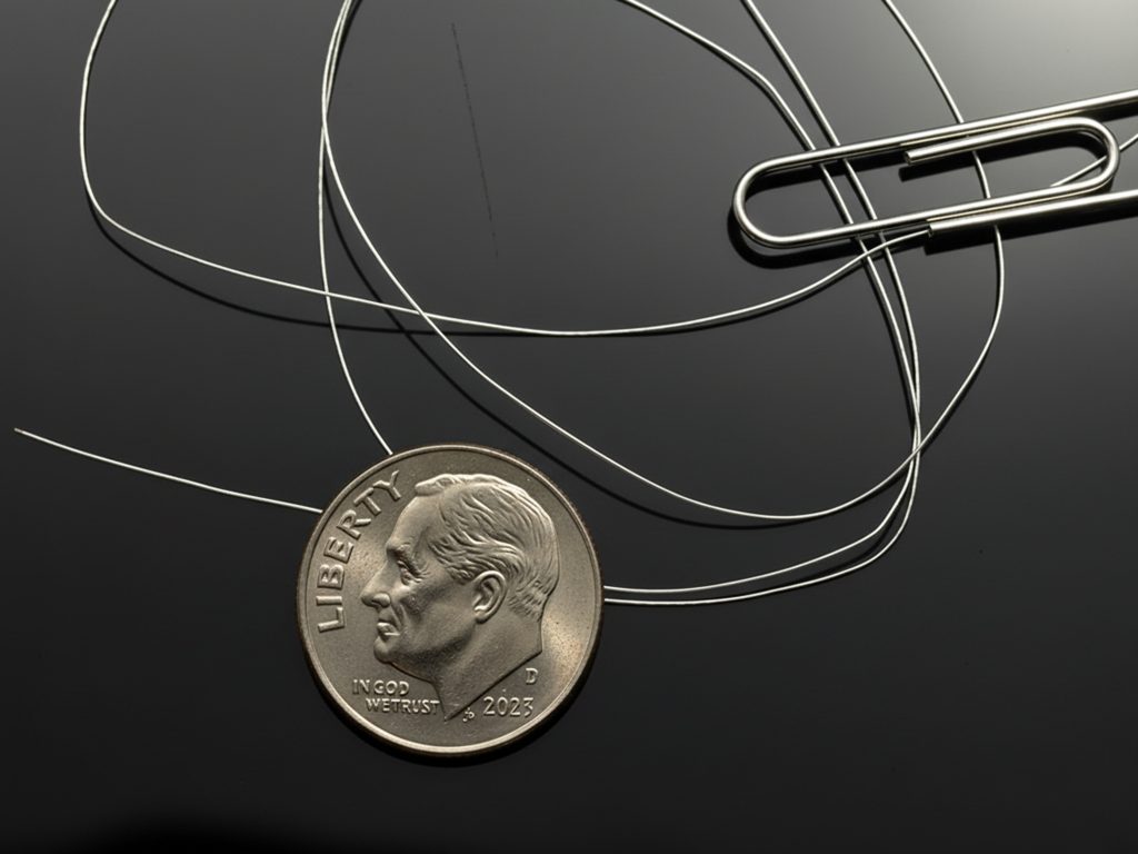 microminiature coaxial cable next to a dime and paperclip for size comparison