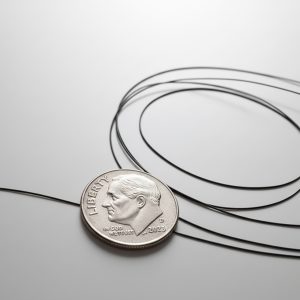 black miniature coax next to a dime for scale