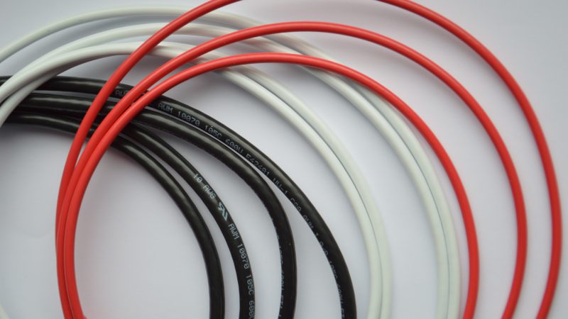 loose pile of black, red, and white power cables with UL markings